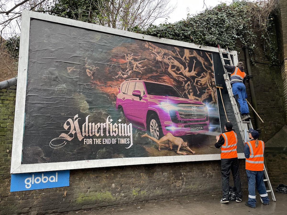 A billboard shows a pink SUV driving through a hellscape.